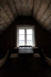 Dark wooden attic room with desk by window