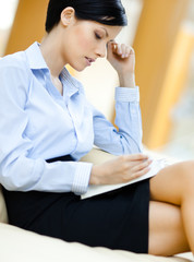 Wall Mural - Business woman rests at the sofa reading book at the hall