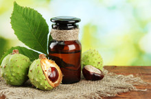 Medicine Bottle With Chestnuts And Leaves, On Green Background