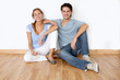 © goodluz - Couple sitting on the floor in new apartment
