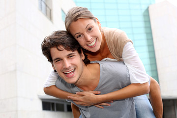 Man giving piggyback ride to girlfriend