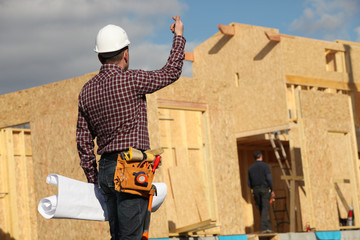 Tradesman standing in front of an unfinished house