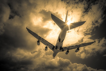 passenger jet landing through golden clouds