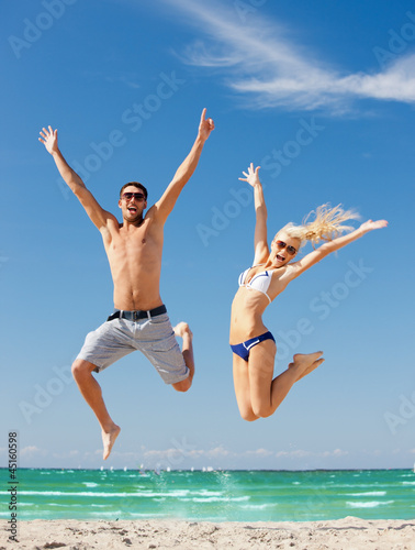 Fototapeta na wymiar happy couple jumping on the beach
