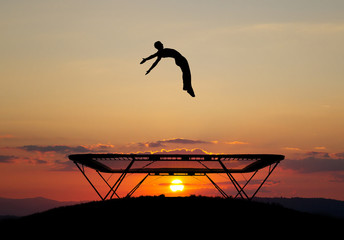 gymnast on trampoline in sunset