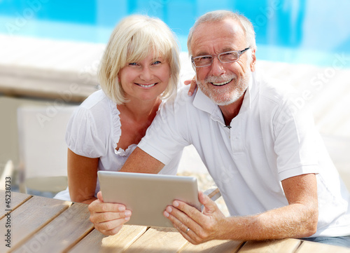 Fotografia, Obraz Different aged couple using a tablet pc outside