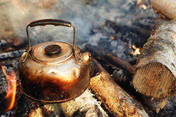 sooty teapot on camping bonfire