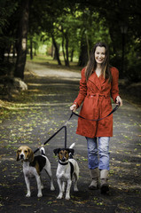 Wall Mural - Young woman and his dogs are walking in the park