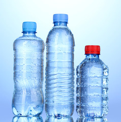 Wall Mural - plastic bottles of water on blue background