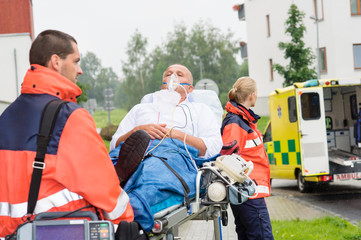 Wall Mural - Paramedics with patient on stretcher ambulance aid