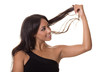 Beautiful woman examines her hair.