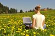 © HappyAlex - Girl with a laptop on the spring meadow