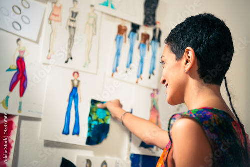 Fotografia, Obraz Female fashion designer contemplating drawings in studio