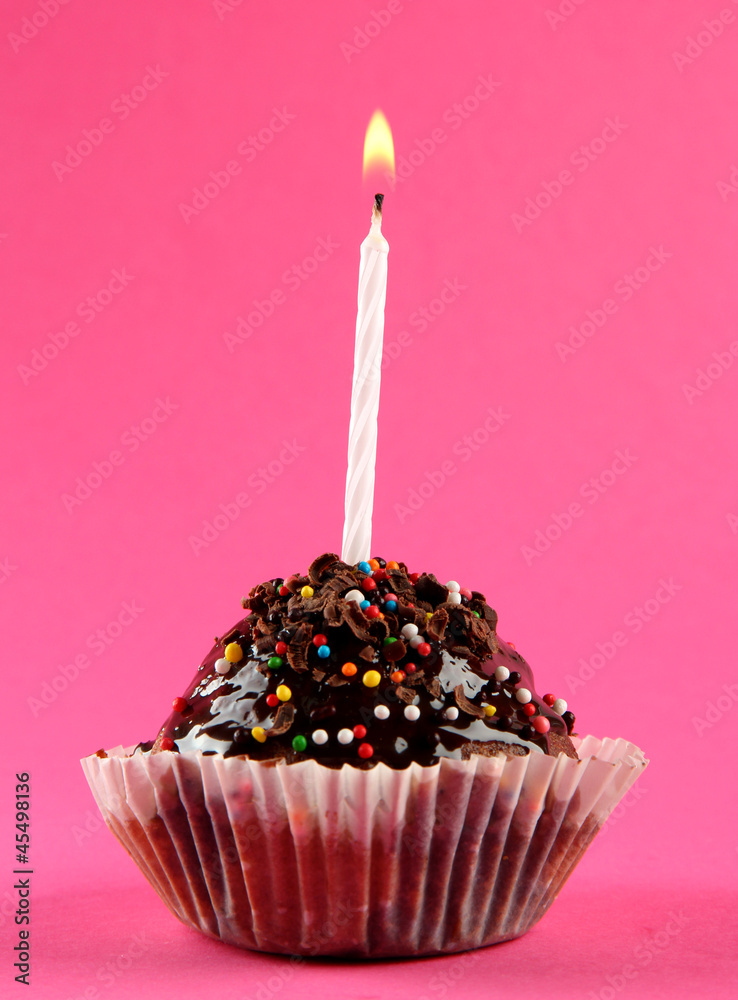 tasty birthday cupcake with candle, on pink background