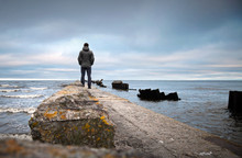 A Man On The Old Broken Pier Starring At The Sea