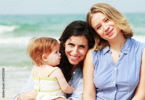 Fotografie, Tablou  two beautiful girls with a baby on the beach