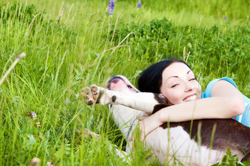 woman with dog playing in the grass