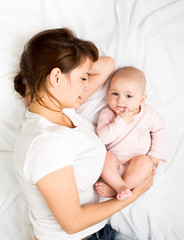 Fototapete - joyful mother playing with her baby infant