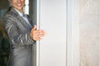 © Alliance - Closeup on business woman hand holding elevator door