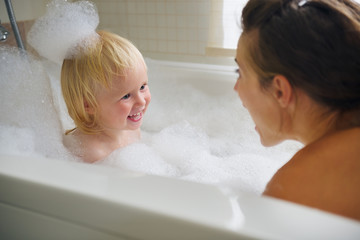 Wall Mural - Mother and baby taking bath and playing with foam