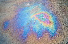 Background Texture Of An Oil Spill On Asphalt Road