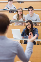 students sitting at the lecture hall listening