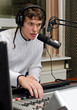 © M-Production - Male dj working in front of a microphone on the radio