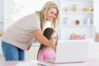 © WavebreakMediaMicro - Mother pointing at laptop with daughter