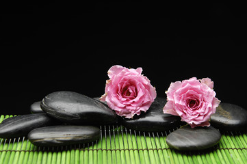 Pink rose with stones on mat