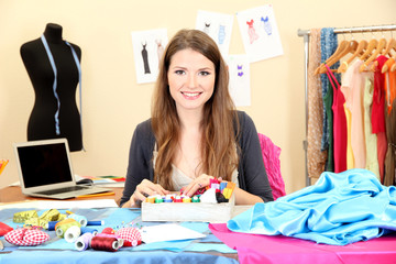 Wall Mural - beautiful young dressmaker in workroom