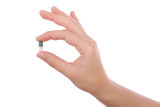 Fototapeta Panele - Hand holding a capsule or pill isolated on white