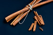 Cinnamon bunch and loose sticks on deep blue background