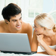© vgstudio - Cheerful couple with laptop, at home