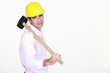 © auremar - businessman holding a helmet and a hammer