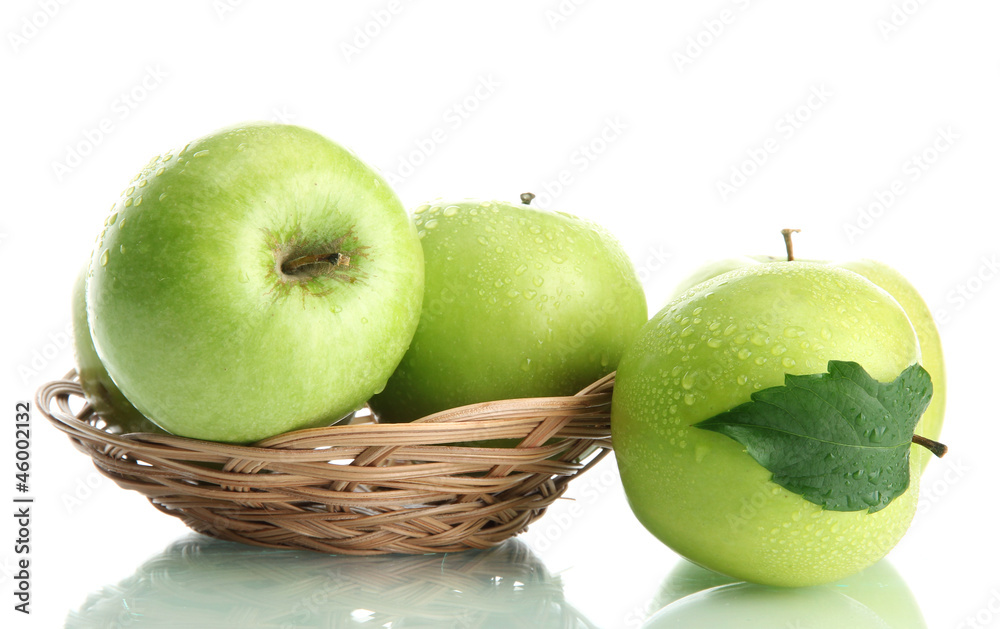 Ripe green apples with leaves in basket isolated on white