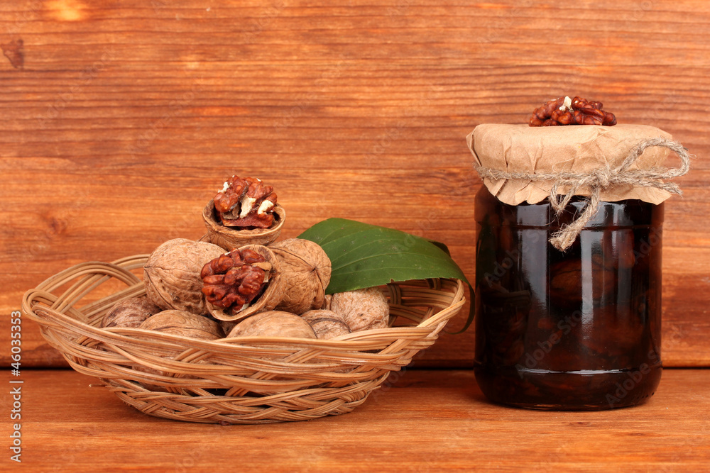 jam-jar of walnuts  and  basket with walnuts on brown