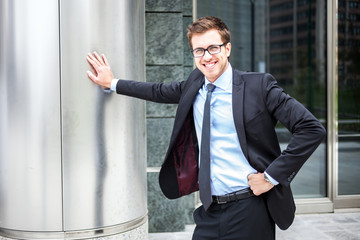 Wall Mural - Businessman leaning on a metal column