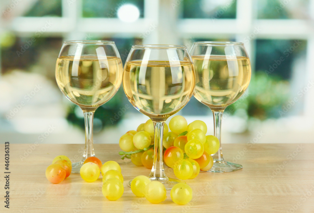 White wine in glass on window background