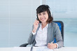 © DragonImages - Smiling customer support representative receiving a client call