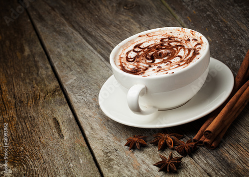 Nowoczesny obraz na płótnie coffee cup and beans, cinnamon sticks, nuts and chocolate on woo