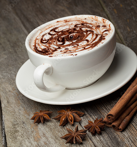 Tapeta ścienna na wymiar coffee cup and beans, cinnamon sticks, nuts and chocolate on woo