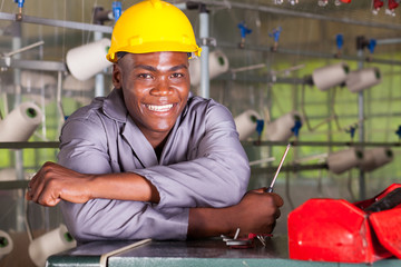 happy african american factory technician repairing loom