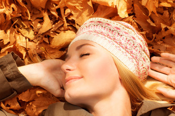 Wall Mural - Pretty woman sleeping on fall foliage