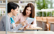 © Karramba Production - Two girls talk sitting at the desk at the library