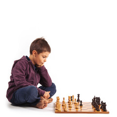 Child playing chess, isolated on white background.