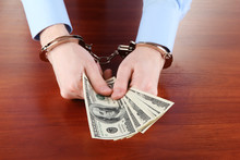Businessman In Handcuffs Counts The Money For Bribes
