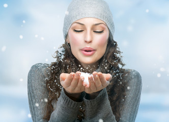 Christmas Girl. Winter woman Blowing Snow