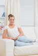© WavebreakMediaMicro - Smiling blonde on sofa