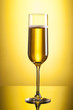 glass of champagne on yellow background