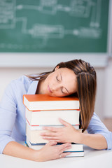 Poster - studentin schläft auf einem stapel bücher